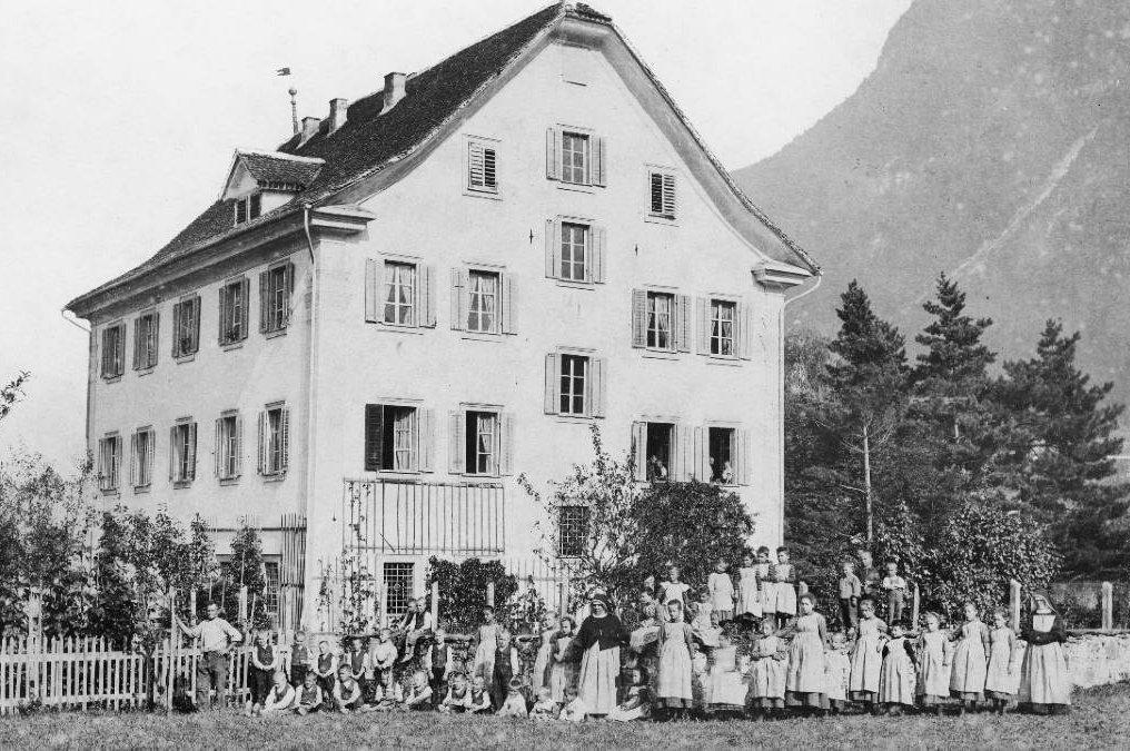 Schwarzweiss Bild Haus mit Kinder und Klosterfrauen